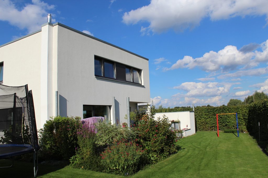 Weißes kubisches Einfamilienhaus mit Garten